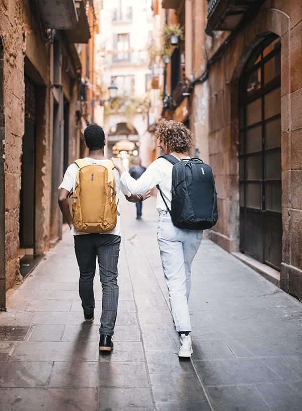 Două persoane pe o alee, cu rucsacuri în spate.
