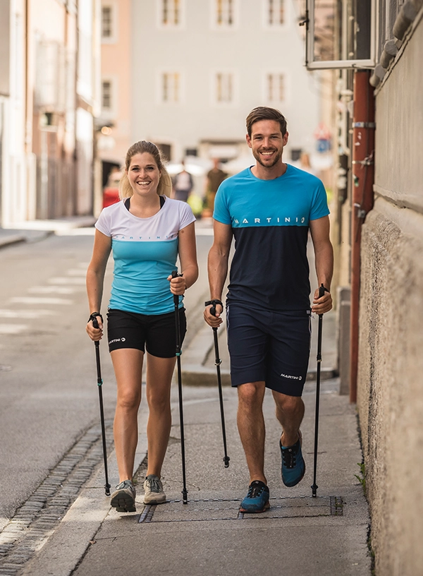 Două persoane practicând nordic walking.
