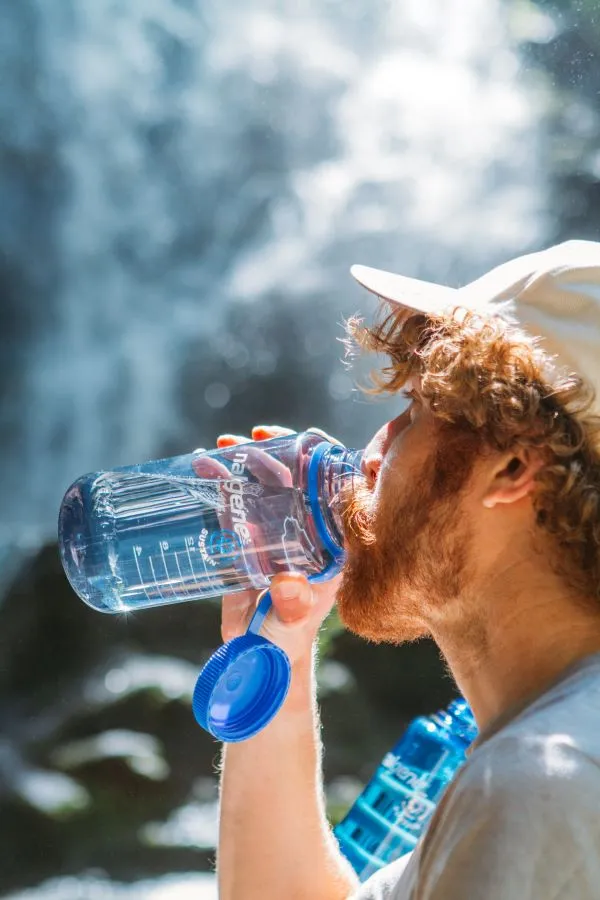 Turist bând apă dintr-o sticlă Nalgene